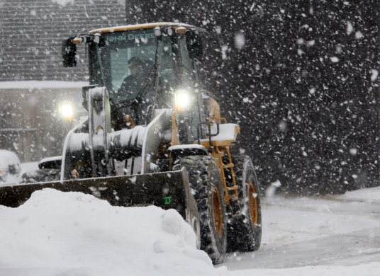 Pat Cavalier, a 28-year snowplow veteran, clears parking lots during a winter storm in Wilton.